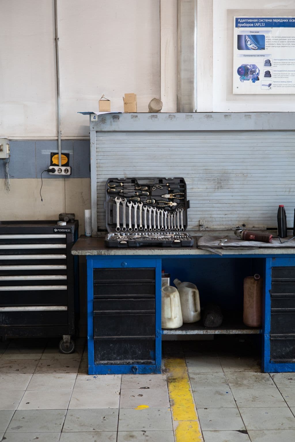 Officina meccanica ordinata con attrezzi a parete e pneumatico in primo piano